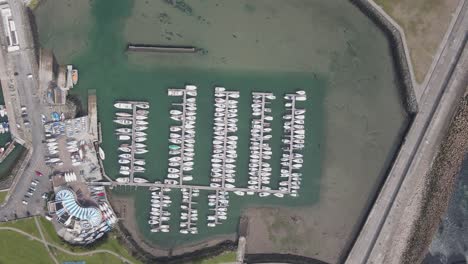 Motor-Boat-and-Sailboats-In-Howth-Harbor-In-Dublin-County,-Ireland---aerial-drone,-top-down