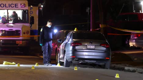 Oficial-De-Policía-Investiga-La-Calle-Crimen-De-Carretera-En-La-Noche-Con-Una-Linterna