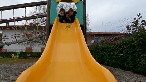 Children-have-fun-together-playing-and-throwing-pebbles-from-the-top-of-yellow-slide