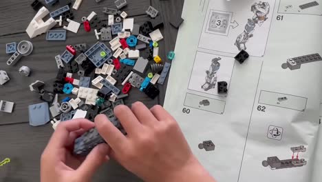 Manos-Pequeñas-Construyendo-Piezas-De-Lego-Usando-Instrucciones-Paso-A-Paso