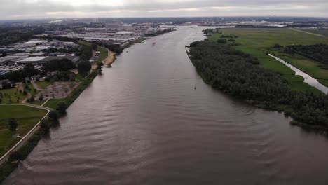 Luftaufnahme-über-Fluss-Mit-Trivor-Binnentanker-Im-Hintergrundabstand-In-Den-Niederlanden