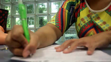 Nahaufnahme-Einer-Jungen-Indonesischen-Studentin-In-Der-Bibliothek,-Die-Studiert-Und-Schreibt