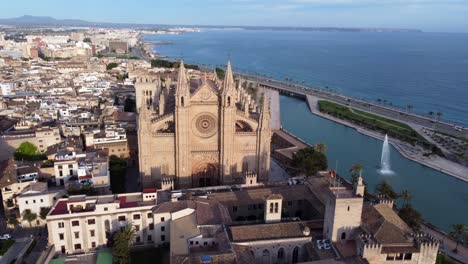 La-Famosa-Catedral-De-Palma,-Conocida-Popularmente-Como-La-Seu,-En-Mallorca,-España-Con-El-Parque-De-La-Mar-Y-El-Mar-Mediterráneo-Al-Fondo