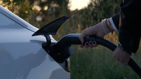 Vehículo-Eléctrico-Tesla-Cargado-Con-Fondo-De-Campo,-Primer-Plano