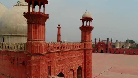 Aerial-View-From-Behind-Red-Sandstone-Wall-Of-Badshahi-Mosque-In-Pakistan
