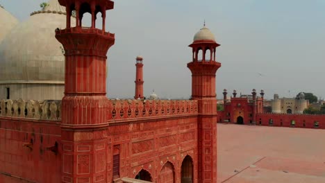 Vista-Aérea-Desde-Detrás-De-La-Pared-De-Arenisca-Roja-De-La-Mezquita-Badshahi-En-Pakistán