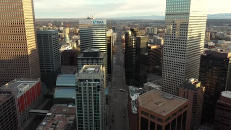 Denver-Downtown-Buildings-on-Golden-Hour-Sun-Drone-Aerial-View,-Central-District-and-Traffic,-Colorado-USA