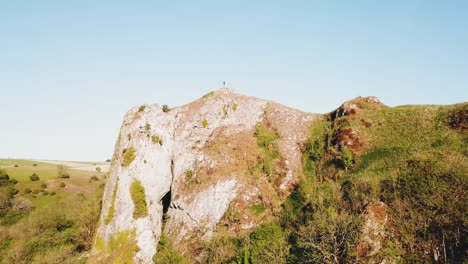 Upwards-aerial-drone-shot-of-Thor's-Cave,-Ashbourne,-Peak-District-from-side