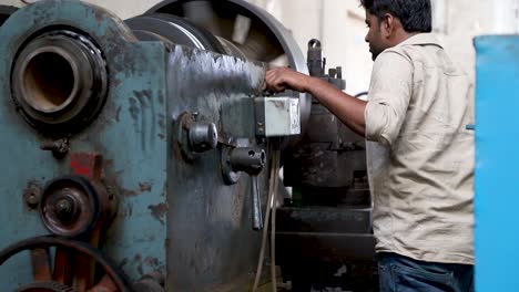 A-man-working-on-Lathe-Machine-and-shaping-the-iron-in-Tools