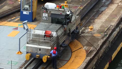 Trabajador-Sujetando-Los-Cables-De-Acero-En-La-Locomotora-Eléctrica-En-Las-Esclusas-De-Gatun,-Canal-De-Panamá