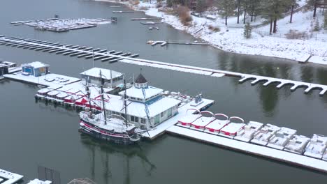 Rotating-aerial-view-of-a-snow-covered-lake-harbor-in-Big-Bear,-California