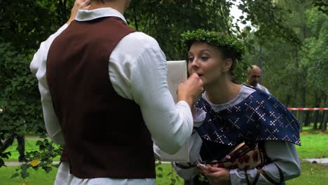 Erwachsene-Kaukasische-Tänzerinnen-In-Traditionellen-Volkskostümen,-Die-Make-up-Vor-Einer-Tanzaufführung-Im-Freien-Fixieren,-Sonniger-Sommerabend,-Fröhliche,-Lettische-Nationalkultur,-Mittlere-Aufnahme