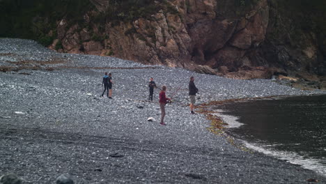 Familia-En-Cañas-De-Pescar-En-La-Orilla-De-Guijarros-De-Porthallow-En-La-Península-De-Lizard-En-Cornualles,-Inglaterra