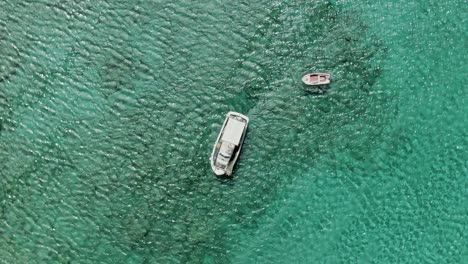 Regular-boat-sailing-on-crystal-clear-water-of-Mediterranean-sea,-aerial-top-down-view