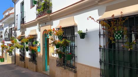 Typical-Spanish-street-in-old-city-Estepona-with-houses,-colorful-flower-pots-and-beautiful-balconies