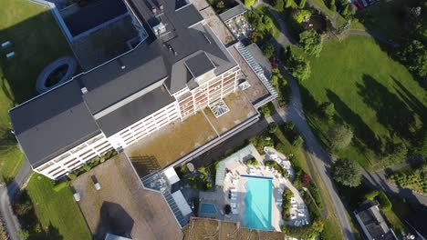 Hotel-Alexandra-Loen-Norway---Top-down-aerial-view-of-hotel-facilities-with-hotel-building-between-swimming-pool-and-lush-evergreen-garden