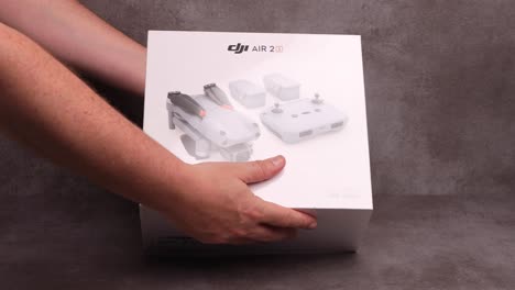 Studio-Rps-Producto-Bodegón-De-Fly-More-Caja-De-Paquete-Combinado-De-Dji-Quadcopter-Portátil-Air-2s-Drone-Sobre-Fondo-Estampado-Metálico-Moderno-Contemporáneo