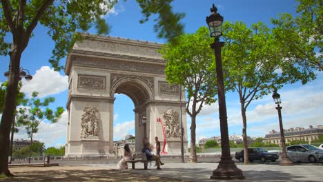 Time-lapse-of-Arc-de-Triomphe-architectural-monument-with-green-trees-and-blue-sky---4k