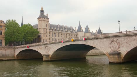 Tráfico-Fluvial-En-Curso-Pasando-Por-Debajo-Del-Puente-Pont-Au-Change-Río-Sena,-Conserjería-En-La-Distancia,-Río-Sena,-Distrito-4,-París,-Francia