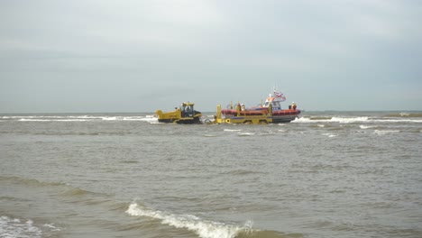 Tractor-Con-Remolque-Remolcando-Bote-Salvavidas-Knrm-En-El-Mar-En-Katwijk,-Países-Bajos