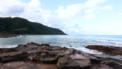 Peaceful-ocean-seaside-view,-waves-lapping-around-rocks