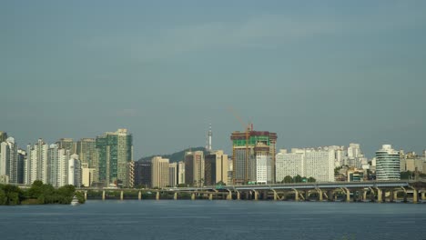 Horizonte-Urbano-De-La-Ciudad-De-Seúl-Desde-La-Orilla-Del-Río-Hangang---Edificio-Bbs-Bulgyobangsongguk,-Apartamento-Del-Obelisco-Hanwha,-Puente-Mapodaegyo-Mapo,-Torre-Namsan-De-Seúl,-Isla-Bamseom,-Vista-Flotante-Del-Paisaje-Del-Yate