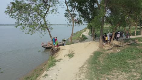 Romantic-Indian-couple-coming-close-to-each-other,-drone-shot-moving-backwards,-near-river-bank