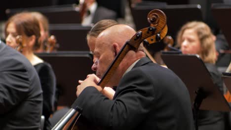 Konzentrieren-Sie-Sich-Auf-Einen-Mann,-Der-Mit-Einem-Orchester-Cello-Spielt,-Saisoneröffnungskonzert-Des-Liepāja-Symphonieorchesters,-Großer-Bernstein-Im-Konzertsaal,-Mittlere-Nahaufnahme,-Selektiver-Fokus