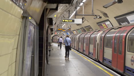 Statische-Aufnahme-Der-Londoner-U-Bahn-Mit-Passagieren,-Die-Auf-Der-Ankunftsplattform-Laufen