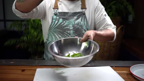 Latin-Chef-mixing-salad-in-a-bowl-slow-motion-flying-food-lettuce