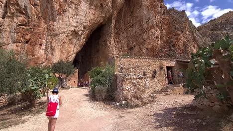 Tourist-taking-selfie-at-Grotta-Mangiapane-or-Scurati-Caves-in-Sicily,-Italy