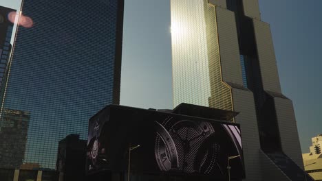 Digital-Billboard-Oled-3D-Screen-on-STtown-Coex-Artium,-Sunlight-reflecting-in-Trade-Tower-at-sunset,-Seoul-South-Korea-static-looking-up