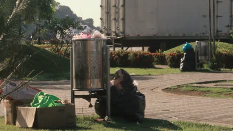 An-overflowing-trash-bin-in-a-park,-the-busy-day-has-left-heaps-of-rubbish-on-the-sidewalk-and-requires-the-support-of-the-Sanitations-Authority-to-be-emptied,-Causeway-of-Amador,-Panama-City