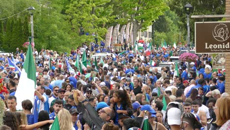 Multitud-De-Hinchas-Italianos-Celebrando-La-Victoria-Del-Torneo-De-Fútbol-De-La-Copa-Del-Euro,-Plano-General---Ondeando-Banderas-Italianas-En-El-Aire