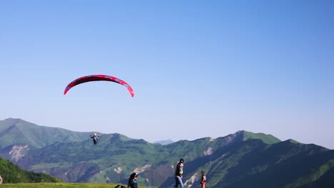 Gleitschirm-Fliegt-über-Dem-Tal-Mit-Der-Hügellandschaft-Von-Kazbegi-In-Der-Ferne