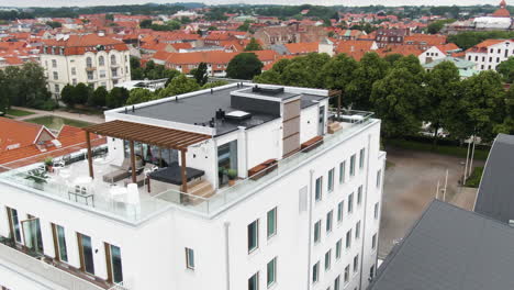 Edificio-De-Hotel-Blanco-De-Fritiden-En-La-Ciudad-De-Ystad-Con-Majestuosa-Terraza-En-La-Azotea,-Vista-De-La-órbita-De-Drones