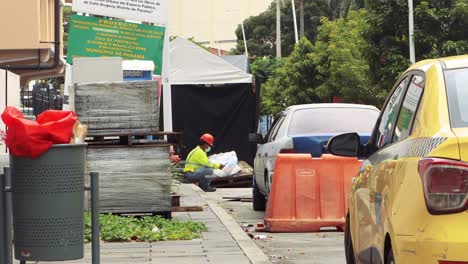 Road-worker-with-face-mask-reads-newspaper,-COVID-19,-Panama-City,-Panama