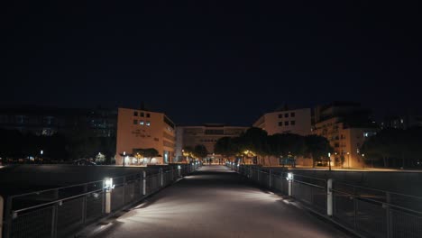 Caminando-Solo-En-Un-Puente-Por-La-Noche-Junto-Al-Agua,-Montpellier---Francia