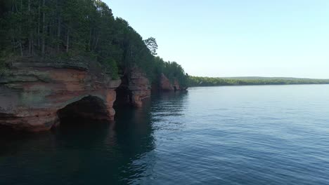 Cinematic-aerial-view-of-caves-inside-cliffs-at-Lake-Superior-Apostolate-island-National-Lake-shore