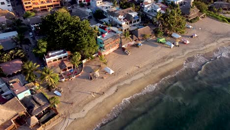 Aerial-drone-view-of-a-quiet-beach-in-Sayulita,-Riviera-Nayarit,-Mexico-during-sunset