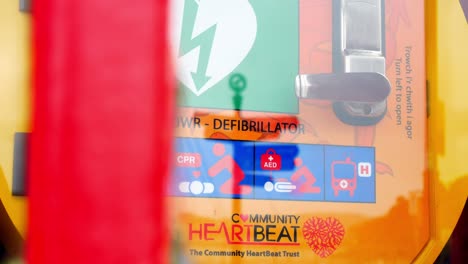 Medizinisches-Notfallkardiologie-defibrillatorgerät-In-Der-Alten-Roten-Britischen-öffentlichen-Dorftelefonzelle-Langsamer-Rechter-Dolly