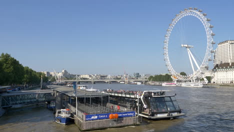 Crucero-Por-La-Ciudad-En-El-Río-Támesis-Con-El-Ojo-De-Londres-En-El-Fondo,-Rueda-De-La-Fortuna-En-Londres,-Inglaterra,-Reino-Unido