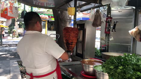 Un-Vendedor-Prepara-Deliciosos-Tacos-Al-Pastor-En-Un-Puesto-De-Comida-Callejera-Mexicana-En-La-Ciudad-De-México
