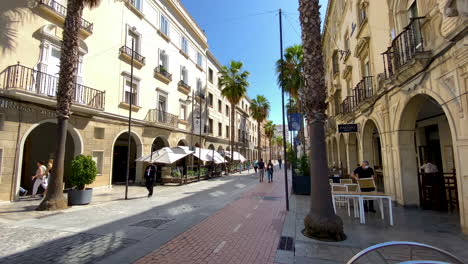 Menschen,-Die-An-Einem-Warmen,-Sonnigen-Tag-Auf-Einer-Gepflasterten-Gasse-Zwischen-Restaurantgebäuden-In-Der-Stadt-Lissabon-In-Portugal-Spazieren