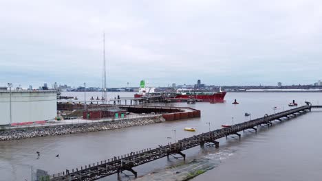 Silver-Rotterdam-oil-petrochemical-shipping-tanker-loading-at-Tranmere-terminal-Liverpool-aerial-view-rising-dolly-right