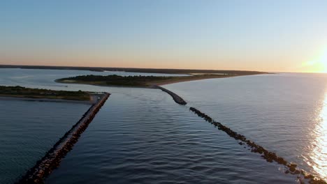 Aerial-backwards-view-of-beach-barriers-at-sunrise