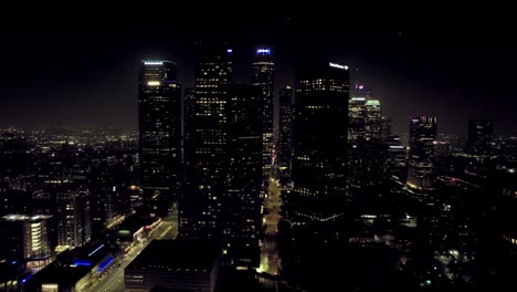 Establecimiento-De-Una-Vista-Aérea-De-Las-Luces-Brillantes-Del-Rascacielos-Del-Centro-De-La-Ciudad-De-Los-ángeles-Torres-De-Oficinas-De-Gran-Altura-Por-La-Noche