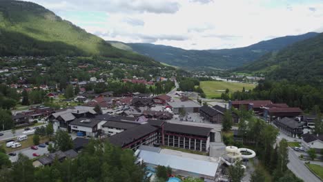 Ciudad-De-Gol-En-Noruega-Con-Hotel-Pers-En-Frente-Y-Valle-De-Hallingdalen-En-El-Fondo---Vista-Aérea-Del-Día-De-Verano