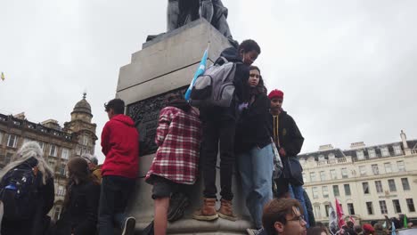 Junge-Leute,-Die-Von-Einer-Statue-Auf-Die-Menge-Herabblicken