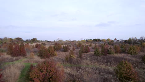 aerial-drone-view,-rise-over-rural-prairie-farmland-in-autumn-as-train-passes-by